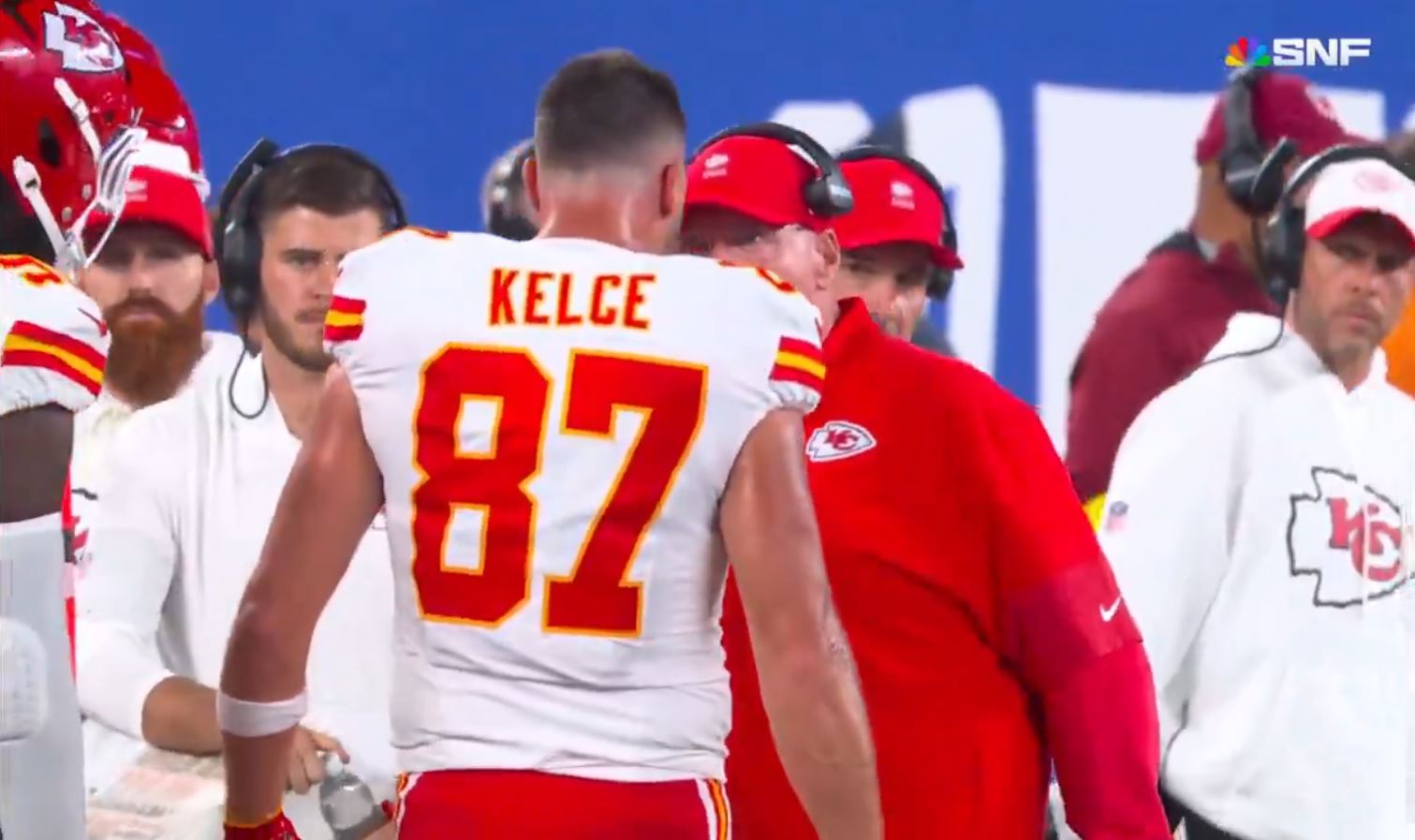 The puppy is stuck between Travis Kelce and Andy Reid