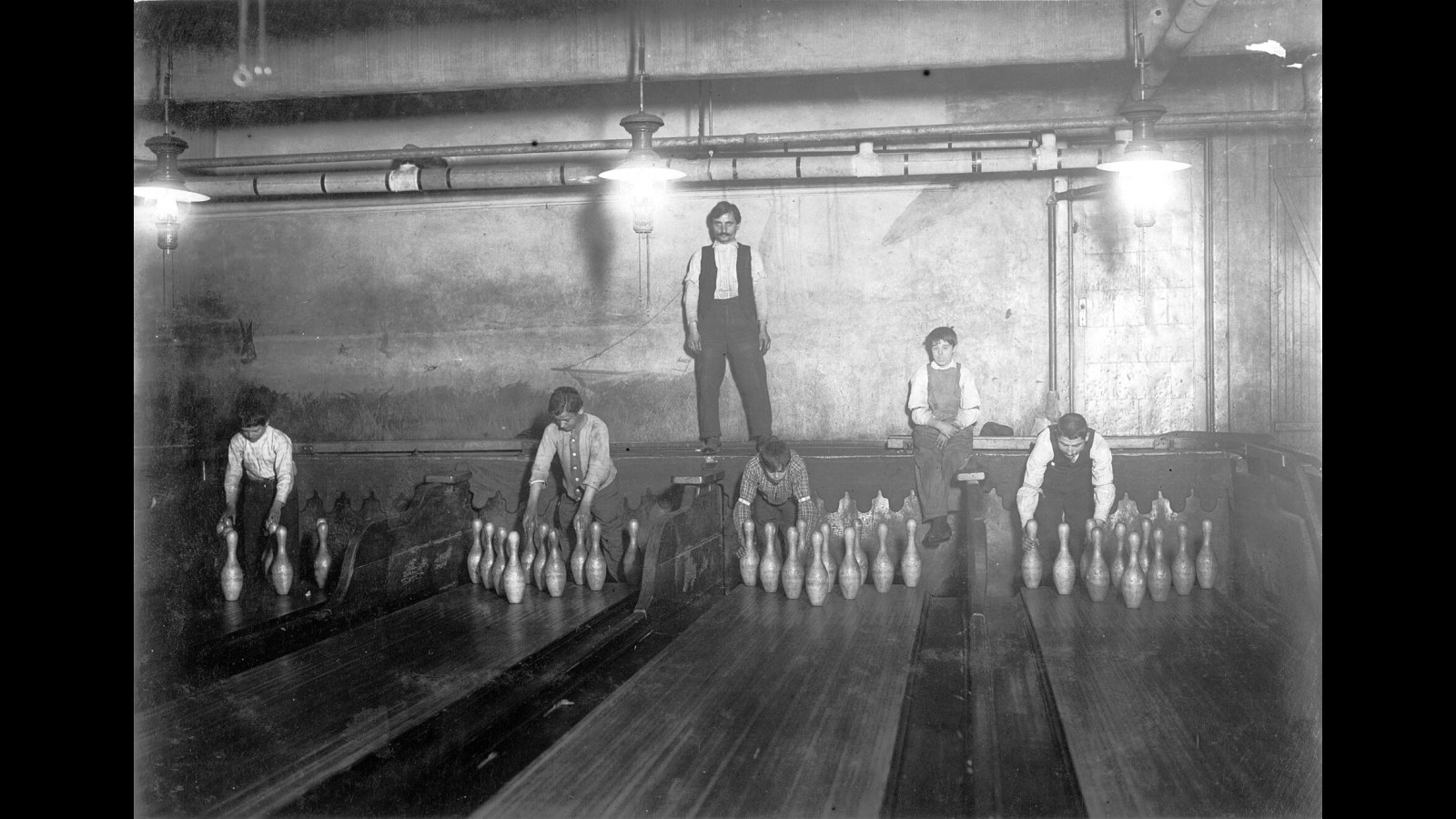 2. Pinboys Reset Bowling Lanes While Dodging Flying Pins